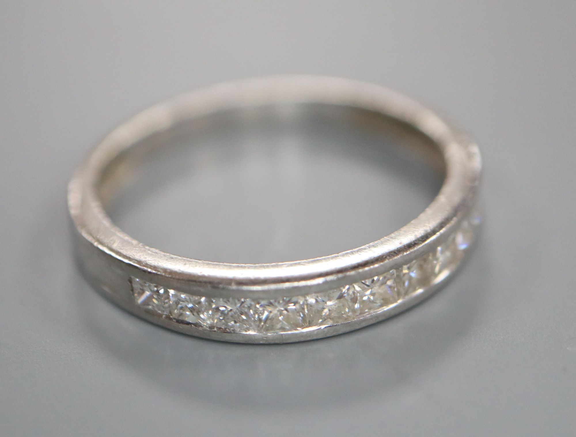 A modern platinum and channel set ten stone diamond half eternity ring, size N, gross 2.9 grams,